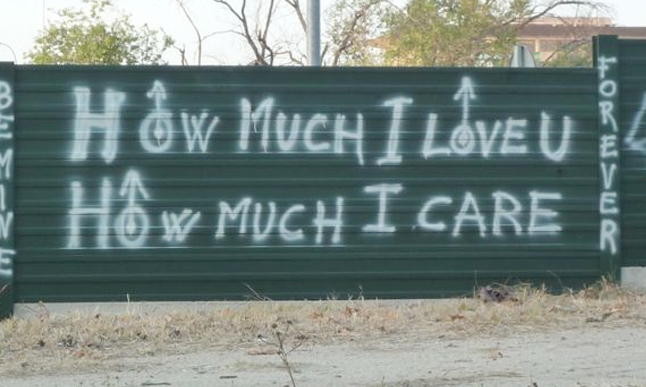 A sign that says how much i love you, and has arrows on it.